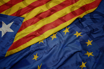 waving colorful flag of european union and national flag of catalonia on a euro money banknotes...