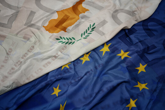 waving colorful flag of european union and national flag of cyprus on a euro money banknotes background. finance concept.