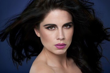 Woman, portrait and hair care with makeup in studio with beauty confidence, breeze or blue...