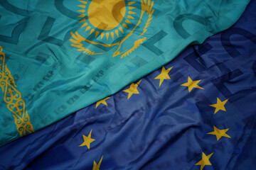 waving colorful flag of european union and national flag of kazakhstan on a euro money banknotes...