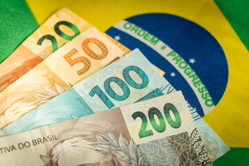 Brazilian money on the background of the national flag, Symbols of Brazil, Economic concept