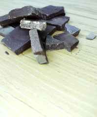 Dark chocolate pieces on wooden table background
