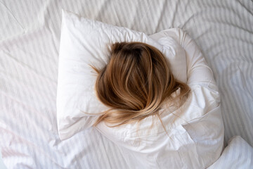 Woman sleep in bed. Blond hair girl under blanket on pillow. Wake up. Dreaming. Happy morning in...