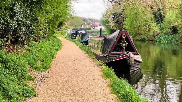 Scenic view of canal boat and picturesque waterway, surrounded by lush greenery and quaint countryside in Apsley, Hertfordshire, England, United Kingdom. High quality 4k footage