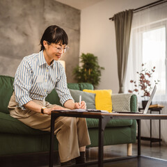Mature japanese woman with eyeglasses work from home sign document