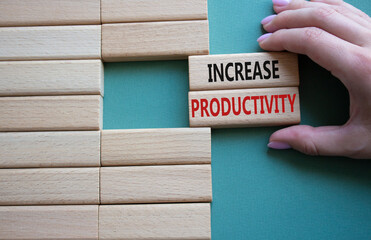Increase Productivity symbol. Wooden blocks with words Increase Productivity. Businessman hand....