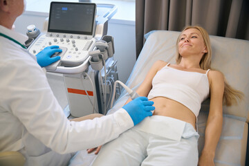 Top view of woman getting ultrasound scan by doctor