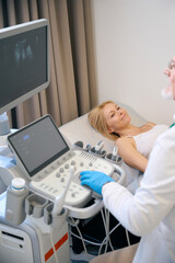 Doctor using ultrasound scan examining pretty woman