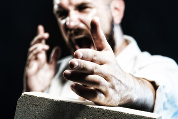 Bearded screaming karate man breaking with hand concrete brick. Mixed martial art fighter in kimono...