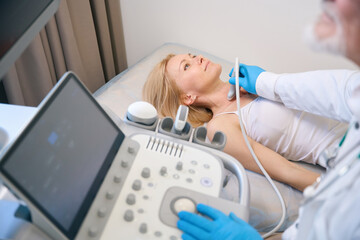 Woman getting thyroid ultrasound exam at clinic