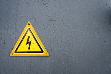 Electricity Warning: Yellow Triangle Sign on Grey Metal Door