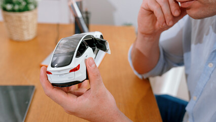 Car design engineer analyze car model prototype for automotive business company at home office....