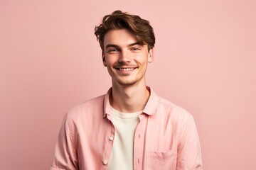 Obraz premium A young man with a pink shirt and a beard is smiling