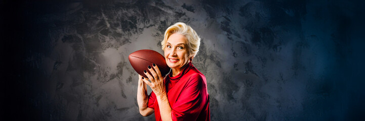 aged woman playing football in studio