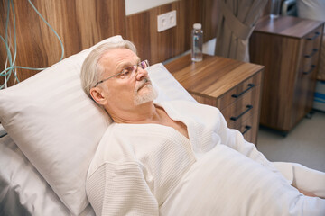 Hospitalized mature man lying in medical ward - 797076199