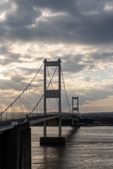 Dramatic sunset behind suspension bridge