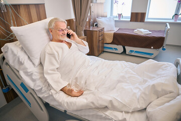 Smiling male patient lying on hospital ward