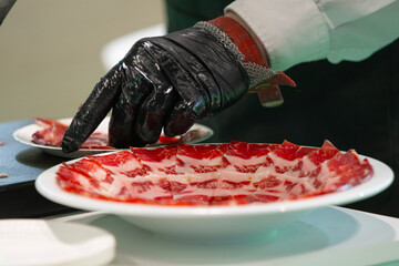 A person is cutting meat on a plate