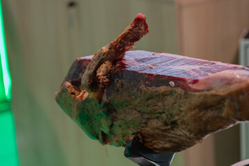 A piece of ham with a red tip and a green background