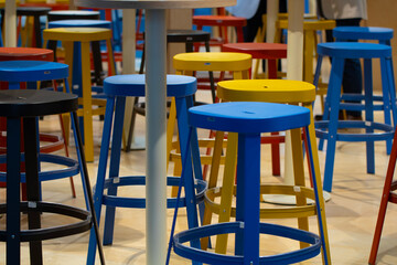 A row of colorful stools are arranged in a room