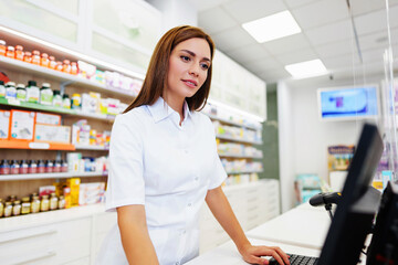 Beautiful pharmacist working and standing in a drug store and doing a stock take. Portrait of a positive healthcare worker or a chemist at his work.