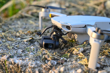 Crashed and damaged drone. Broken arms and camera gimbal of drone on asphalt road. Drone fell to...