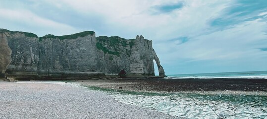 Majestic Limestone Cliffs Overlook the Tranquil Sea Under a Softly Brooding Sky