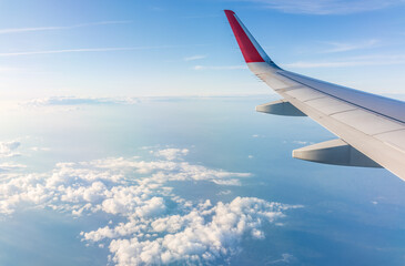 Obraz premium View from the airplane window at a beautiful cloudy sky and the airplane wing