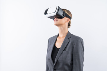Manager wearing visual reality glasses and looking around and explore at metaverse and visual world. Caucasian business woman standing and using VR glasses and technology innovation. Contraption.