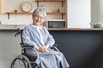 自宅のダイニングで車椅子に座る高齢者女性
