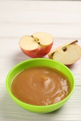 Baby food. Puree of apples in bowl on white wooden table