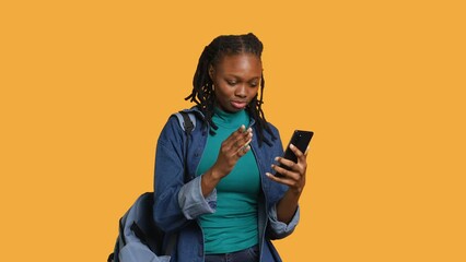 Upset african american woman arguing with friends during teleconference meeting on smartphone, studio background. Annoyed girl fighting on mobile phone videocall with mates, camera A