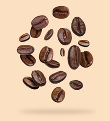 Roasted coffee beans falling on beige background
