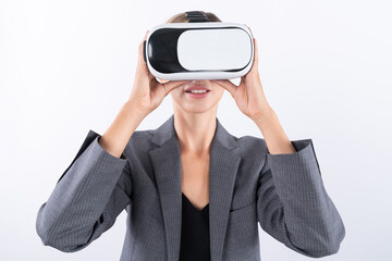 Skilled businesswoman looking at visual reality world by using VR glass while standing at...