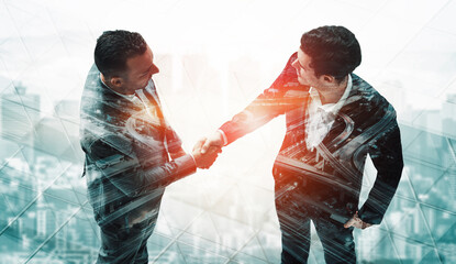 Double exposure image of business people handshake on city office building in background show...