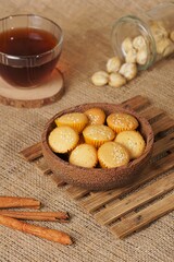 Sesame cake on a wooden plate on a brown cloth background, photographed with studio lights