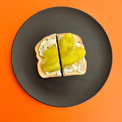 Toasted rustic white bread with a sour cream and chives spread and dill pickle slices.