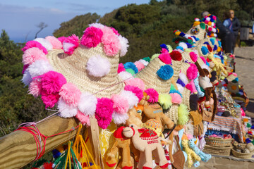 Souvenir hats and toys for sale at a seaside viewpoint near Tangier, Morocco.