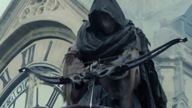 Masked vigilante in tattered robes stands atop Gothic clock tower, silver-tipped crossbow at the ready. Ominous atmosphere suggests dark purpose and impending action against injustice.
