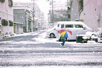 雪の中傘をさして歩く子供