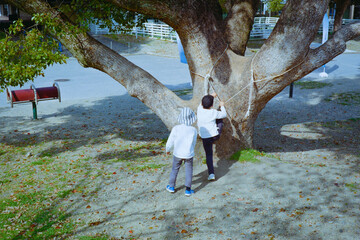 木登りをして遊ぶ子供