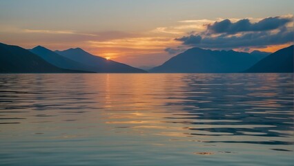Fototapeta premium Serene sunset over a mountain lined lake with reflections