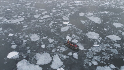 People in rubber inflatable motor boat sail in Antarctic ice. Zodiac in Icebergs, Tracking Aerial...