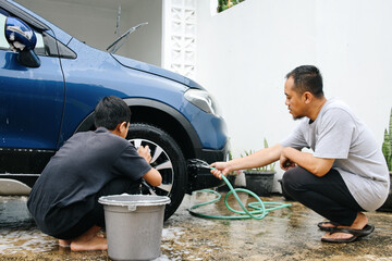 Father and Son Washing Car Together on The Weekend 