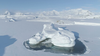 Fototapeta na wymiar Melting Ice - Iceberg Frozen. Antarctica Aerial View Climate Change. Antarctic Winter Glacier in Nature Majestic Coast Landscape. Big Ice Piece Stuck in Frozen Water. Drone Tracking Flight.