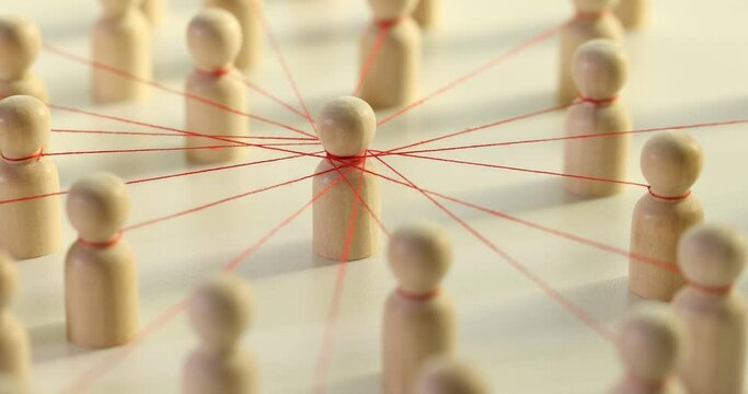 Wooden figures connected with red threads