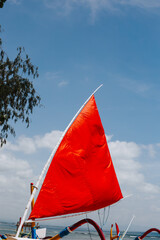 Red sail of a boat on the background of the sky