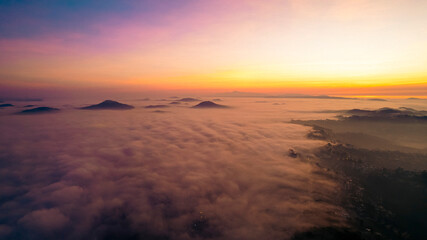 a breathtaking view of Dalat City at sunrise, enveloped in mist. The serene landscape features...