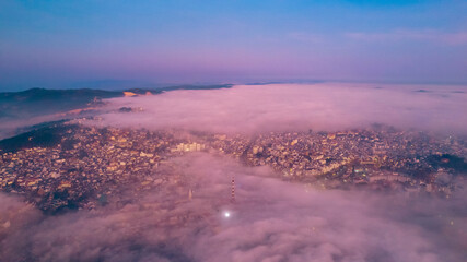 A city emerges from a sea of fog in the early morning light, at Dalat city, Vietnam