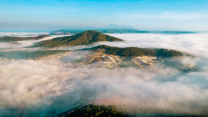 a breathtaking view of Dalat City enveloped in mist, with mountains, forests, and buildings peeking...